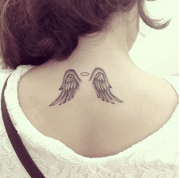 A Small Tattoo On The Leg Of A Woman With Angel Wings And An Oval Halo